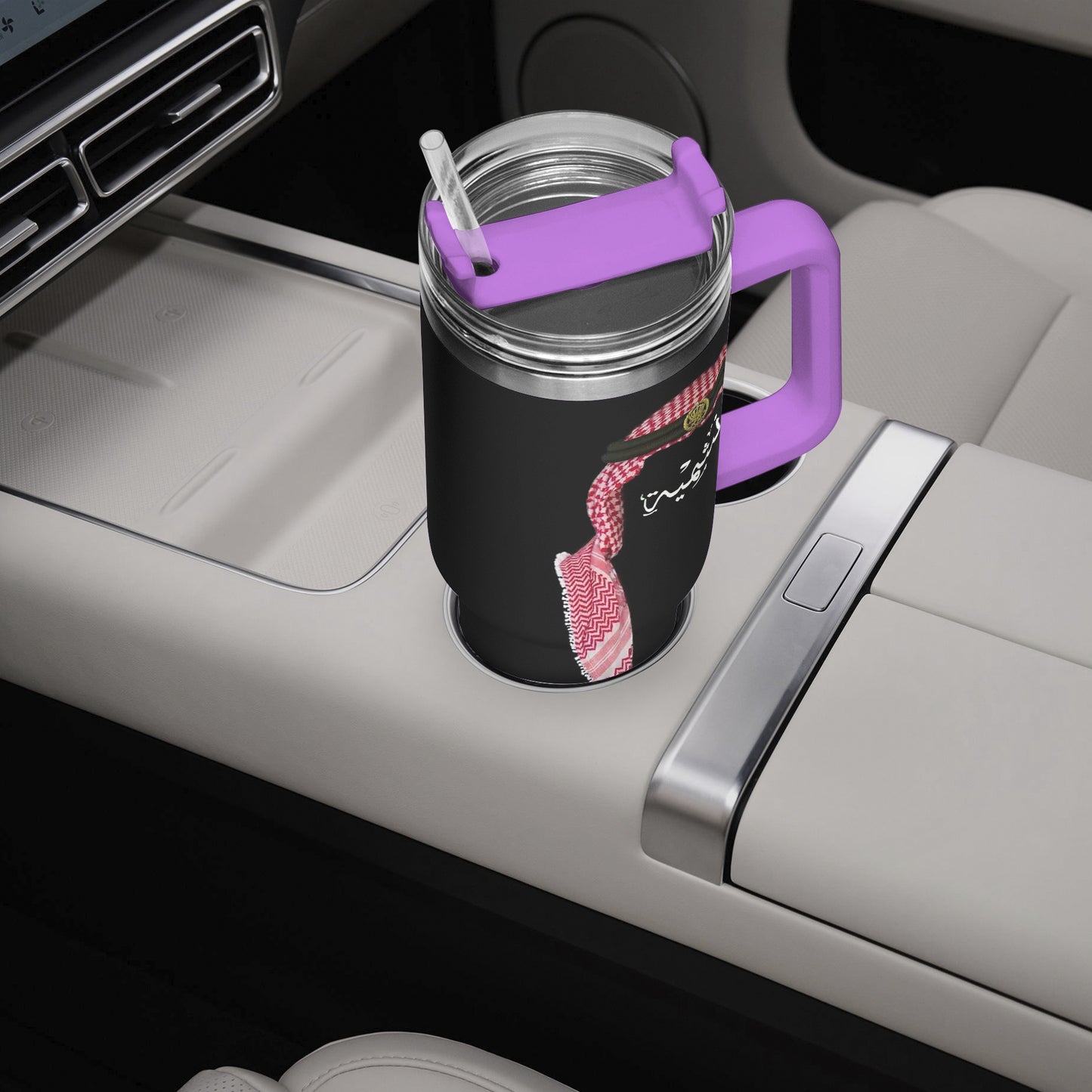 Black tumbler with pink design and purple handle in a car cup holder