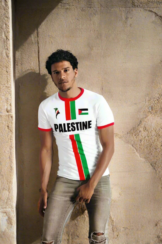 Person wearing a white t-shirt with Palestinian flag design on a plain background