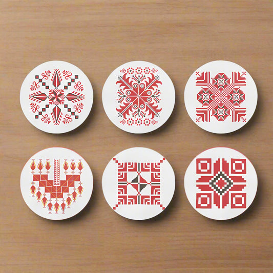 Set of six coasters with red geometric tatreez patterns on white background
